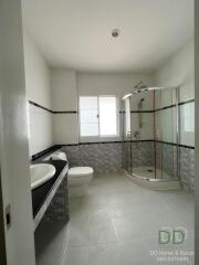 Spacious modern bathroom with dual sinks and glass shower enclosure