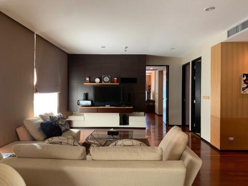 Spacious and modern living room with wooden floors and large windows