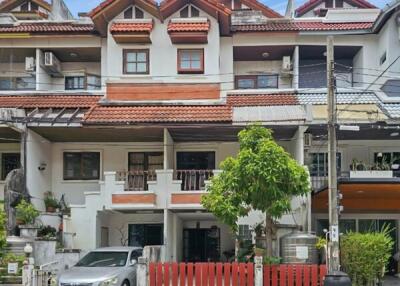 Exterior view of a townhouse with parked car