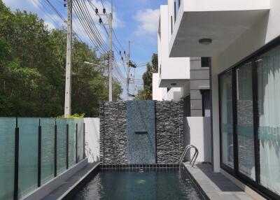 Modern home exterior with swimming pool and waterfall