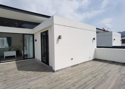 Modern exterior view of a house with large sliding doors and wooden decking