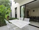 Modern patio with dining area and sliding doors opening to the interior