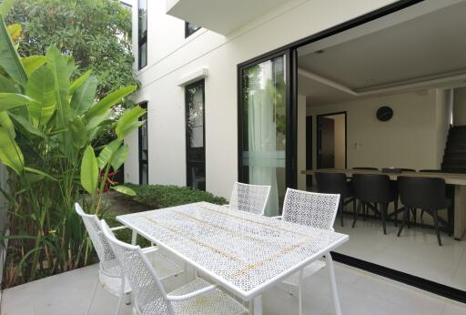 Modern patio with dining area and sliding doors opening to the interior
