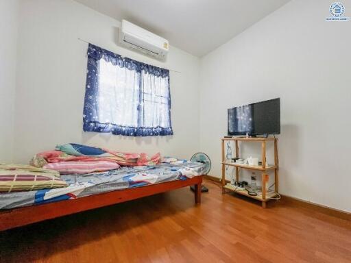 Well-lit bedroom with air conditioning and TV setup