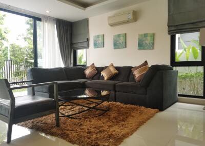 Spacious and well-lit living room with large sofa and balcony access