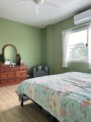Spacious bedroom with green walls and large window