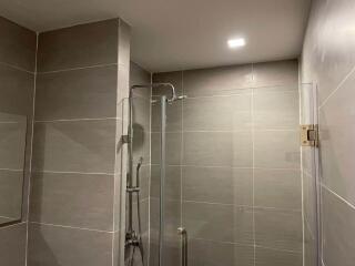 Modern bathroom with neutral tiled walls and shower area