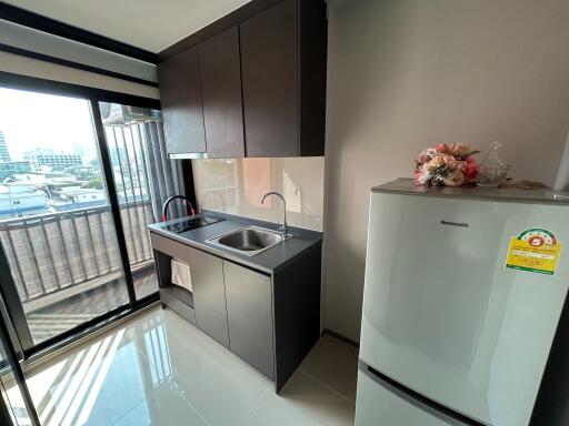 Modern kitchen with stainless steel sink and large refrigerator near window