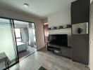 Modern living room with adjoining bedroom visible through glass doors