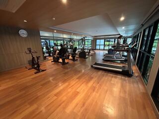 Spacious home gym with various exercise equipment and natural light