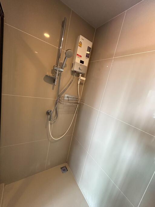 Modern bathroom with wall-mounted electric shower and glossy tiles