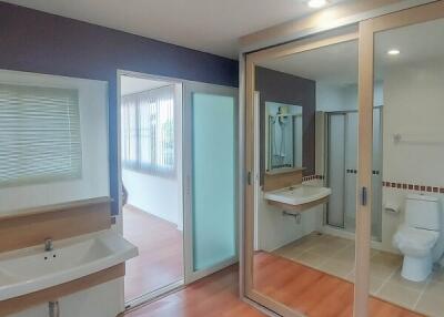 Spacious and modern bathroom with reflective glass doors and ample lighting