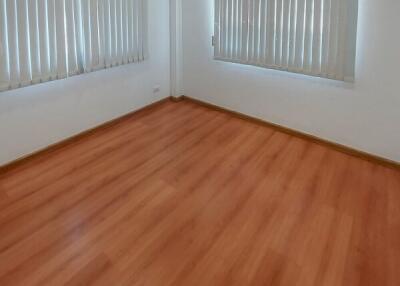 Empty bedroom with wooden floor and white curtains