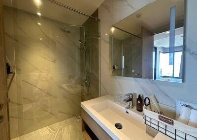 Modern bathroom with marble finish and well-lit mirror