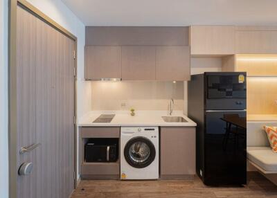 Compact modern kitchen with integrated appliances and seating area