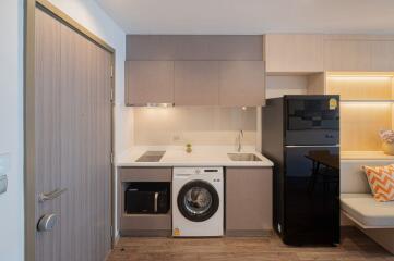 Compact modern kitchen with integrated appliances and seating area