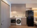 Compact modern kitchen with integrated appliances and seating area