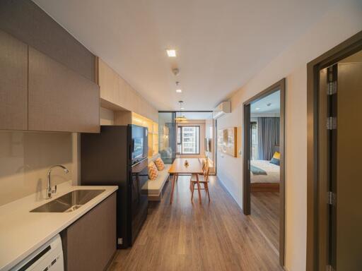 Modern apartment interior view showing open plan kitchen leading to a bright living area