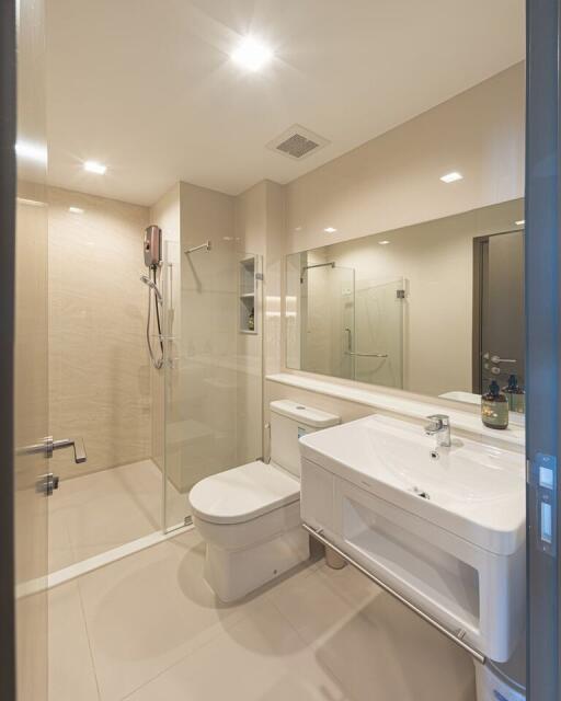 Modern bathroom with glass shower, large mirror, and white fixtures