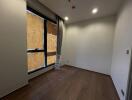 Unfurnished bedroom with wooden flooring and large window