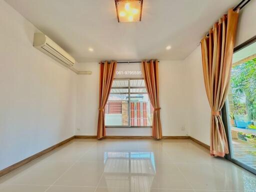 Spacious and well-lit living room with large windows and air conditioning