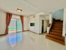 Spacious living room with staircase and bright natural lighting