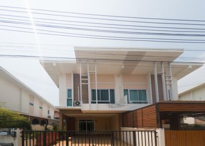 Modern two-story residential home with clear sky and power lines