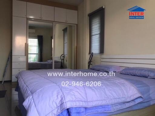 Spacious and well-lit bedroom with large bed and ample storage