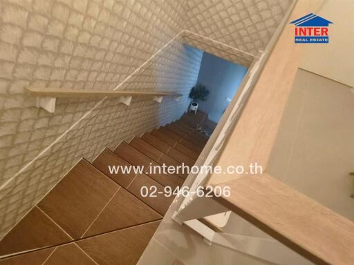 Modern staircase in a residential building with wooden steps and white walls