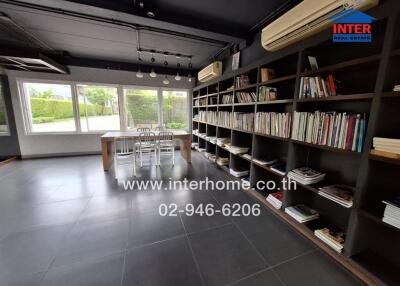 Spacious modern living area with bookshelves and dining set