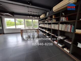 Spacious modern living area with bookshelves and dining set