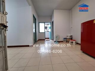 Spacious unfurnished living area with white walls and tiled floors