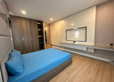 Modern bedroom with built-in wardrobes and wooden flooring