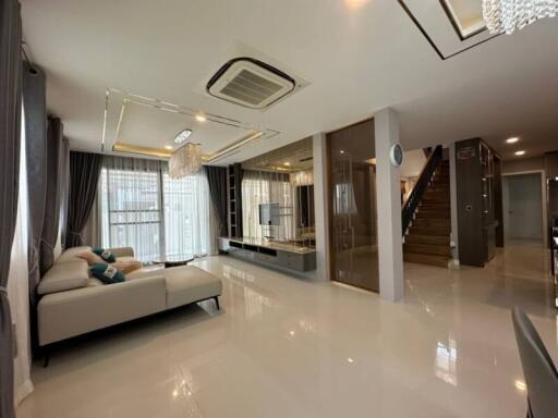 Spacious and well-lit living room with modern decor and luxurious finishes