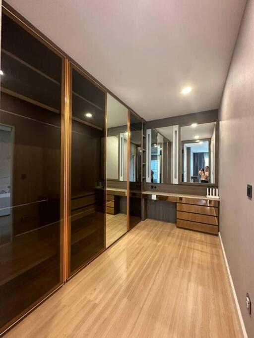 Spacious bedroom with large mirrored closet and wooden flooring