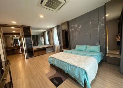 Spacious modern bedroom with large bed and mirrored wardrobe
