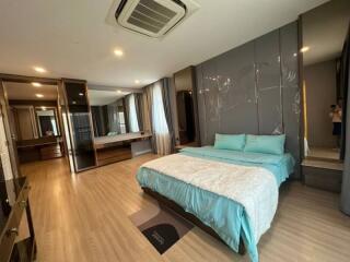 Spacious modern bedroom with large bed and mirrored wardrobe