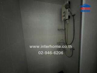 Modern gray tiled bathroom with wall-mounted shower and water heater