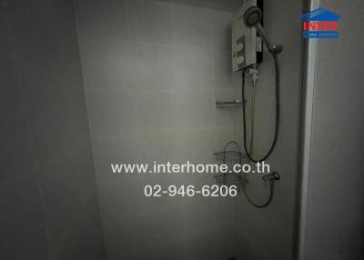 Modern gray tiled bathroom with wall-mounted shower and water heater