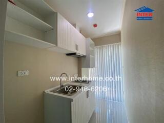 Compact fully equipped kitchen with white cabinets and modern appliances
