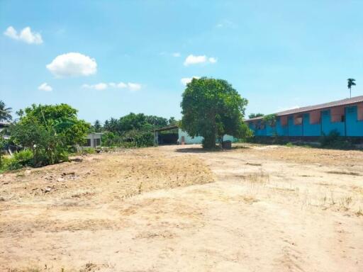 Empty plot of land with surrounding buildings under a clear blue sky