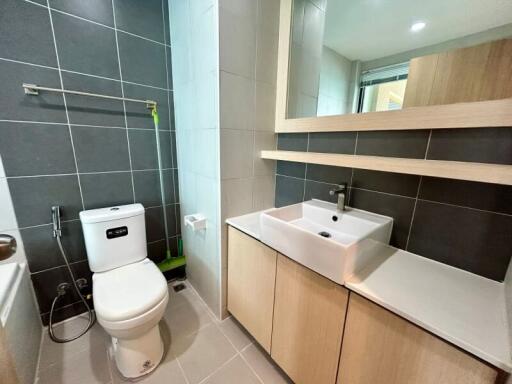 Modern bathroom with wooden shelves and ceramic fixtures