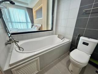 Modern bathroom with bathtub and adjacent bedroom view