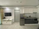 Modern compact kitchen with integrated appliances and television