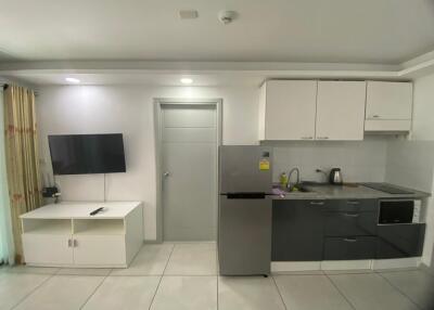 Modern compact kitchen with integrated appliances and television