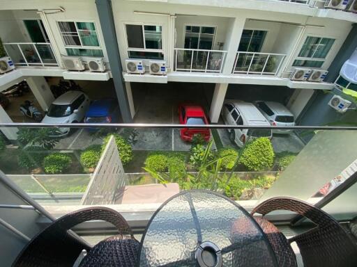 View from balcony showcasing residential building and parking area