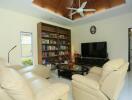 Spacious and well-lit living room with modern furnishings and a large bookshelf