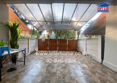 Spacious covered patio area with tiled flooring and greenery