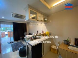 Spacious living room with integrated kitchen area and access to balcony