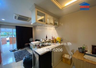 Spacious living room with integrated kitchen area and access to balcony